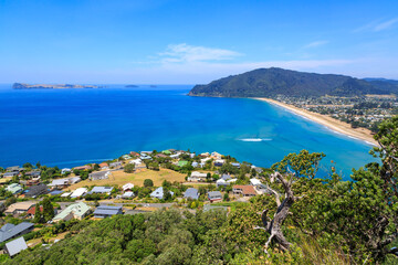 The neighboring holiday towns of Tairua (foreground) and Pauanui on the Coromandel Peninsula, New Zealand. In the ocean is Slipper Island, a resort