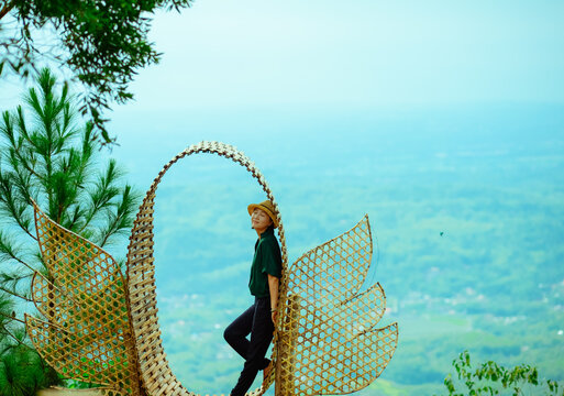 Single Asian girl having fun on mountain park at Hutan Pinus Pengger, Yogyakarta, Indonesia.