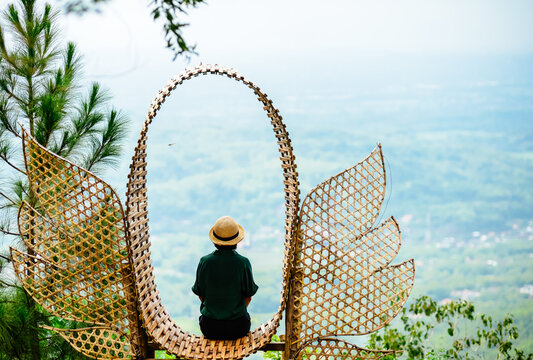 Single Asian girl having fun on mountain park at Hutan Pinus Pengger, Yogyakarta, Indonesia.