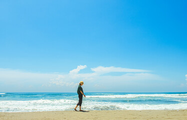 Fototapeta na wymiar single girl enjoys herself standing on Parangtritis beach, Yogyakarta, Indonesia.