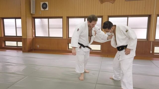 A Judo Sensei demonstrates how to enter into a Reverse shoulder throw (seoinage) in a traditional Japanese Dojo.