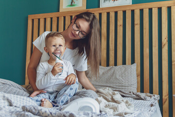 Woman with son doing inhalation with nebulizer at home