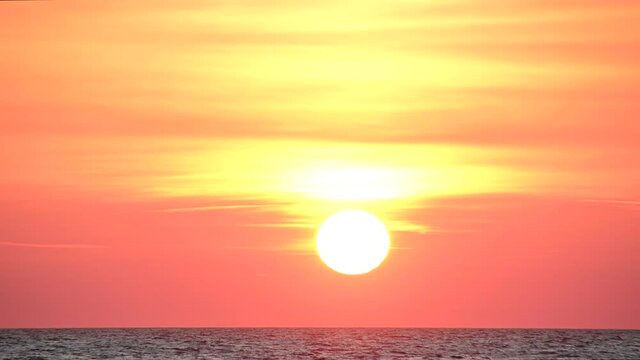 A dramatic sunset passing behind Adriatic Sea horizon. Empty ocean view. Long-focus lens, static shot, real time, 4K