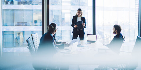 Businesswoman presenting project to coworkers in office