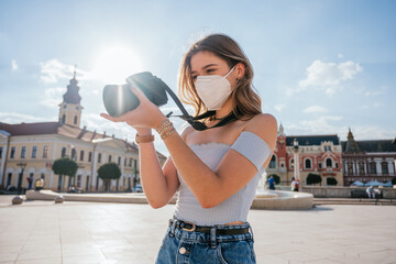 Tourist woman wearing mask and taking pictures