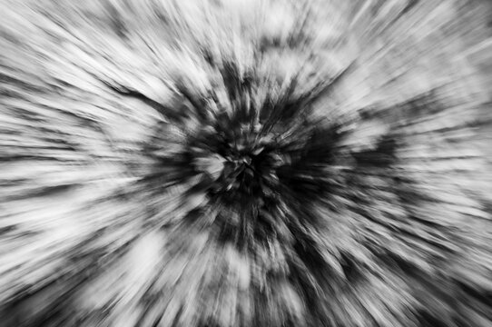 Abstract black and white zoom burst of a jagged rock formation producing an explosive effect.