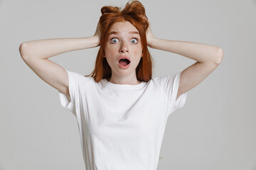 Image of surprised ginger beautiful girl grabbing her head