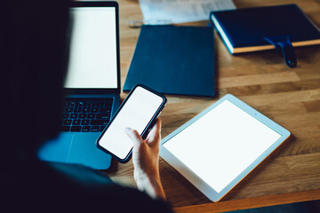 Cropped image of woman holding mobile phone with blank screen share multimedia files via bluetooth...