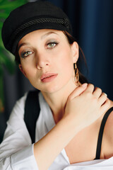 Portrait of a beautiful young woman in a white shirt and black pants in the Studio