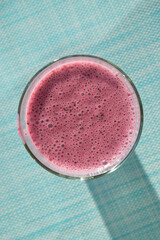 Fresh blueberry kefir smoothie in glass, top view.