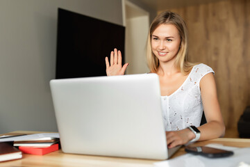 Fototapeta premium Video call, video conference with other people on laptop indoors. Online learning and work. Woman with laptop computer working at home office