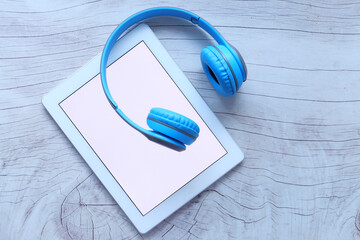 Audio book concept. Headphones and digital tablet on table 