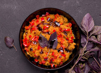 Vegetarian soy meat dish with basil and pepper on a black background. View from above