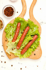 Vegetarian meat concept. Sausages from soybeans and spices on a wooden board. Vertical photo, top view