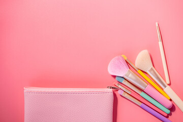 Make up brushes with powder on pink background