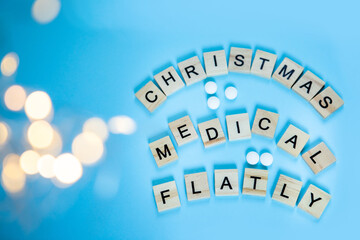 Wooden letters with the inscription christmas medical flatly on a blue background