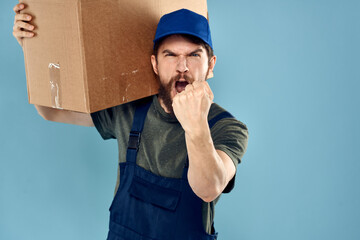 A man in working uniform with boxes in the hands of a carriage delivery service blue background