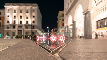 Urban movement in a night square. Victory Square, Brescia, Italy..