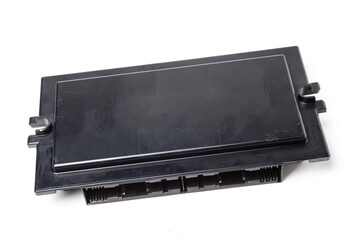 A stripped part with a connector from a car on a white isolated background is a plastic electronic control unit for replacement and repair. Spare parts catalog for sale.