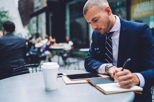 Focused entrepreneur working with tablet in street cafe - Powered by Adobe