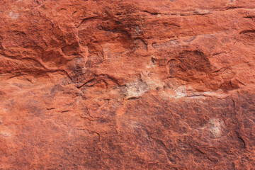 Textured surface of red stone.