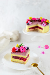 A slice of raspberry lemon cake with flowers on a white plate. Sugar, lactose, gluten free. Healthy food, no baking.