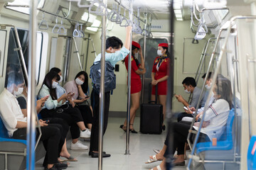 Crowd of passengers on Urban Public Transport Metro. .Asian people go to work by public transport. Face Mask protection against virus. Covid-19, coronavirus pandemic