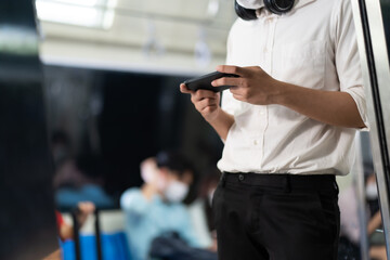 Young Hand some Asian business man with smartphone in public transport electric train.