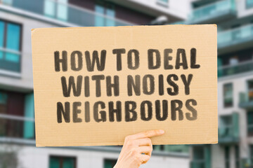 The question " How to deal with noisy neighbours " on a banner in men's hand with blurred background. Neighbour. Noise. Apartment. Flat. Drill. Wall. Tired