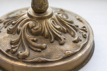 Leg of antique bronze candlestick on white background