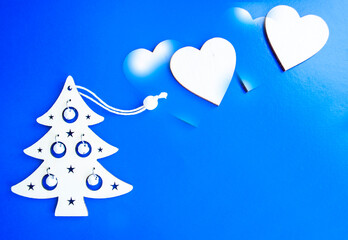 Fototapeta na wymiar new year layout. wooden toy christmas tree and wooden heart on a blue background