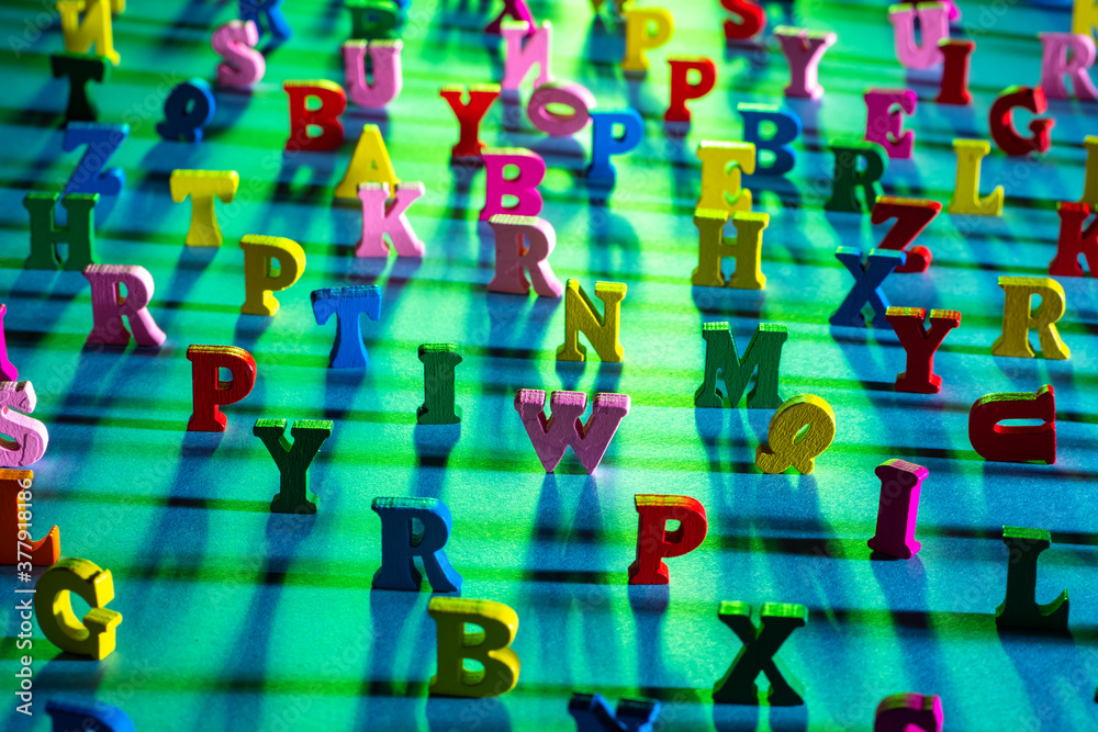 Fototapete latin characters with focus in the center. english letters stand on a green background and cast shad