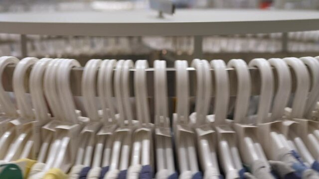 Close up of round rail with spinning white hangers with clothes