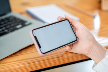 Mock up. image of woman holding mobile phone with blank white screen.