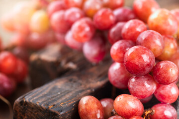 Fresh ripe red grapes on wooden board close up