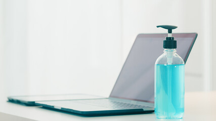 Hand sanitizer gel for hand hygiene corona virus protection with computer laptop. Social distancing stay at home and self quarantine time, online shopping, coronavirus concept.