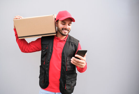 Happy delivery man with package and smartphone