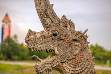 Fototapeta premium The background of the Wat Pa Kham Charoen is a beautiful old church with a Buddhist statue and a tree-lined temple, with tourists and travelers always making merit in Udon Thani, Thailand.