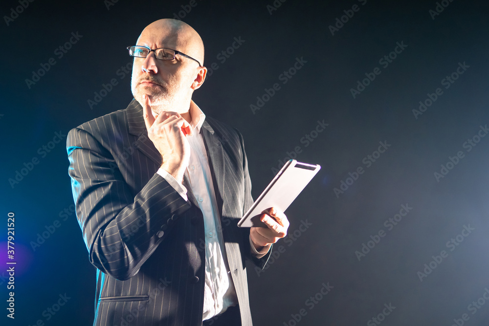 Poster a person is thinking and holding a tablet computer. a scientist with an electronic tablet in his han