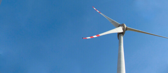 Windmill on a background of blue sky. Bottom view. Clean energy concept