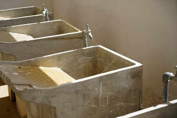 Row of old-fashioned laundry sink with washboard