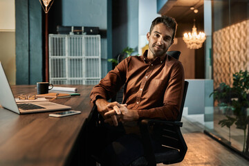 Confident businessman working late at his desk in an office