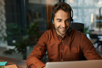 Smiling businessman talking on a headset with a client