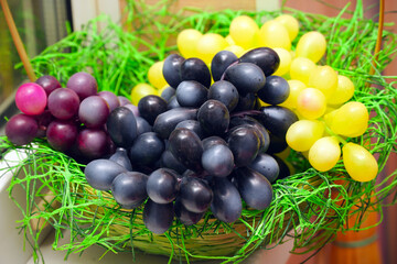 Bunches of artificial grapes on a plate