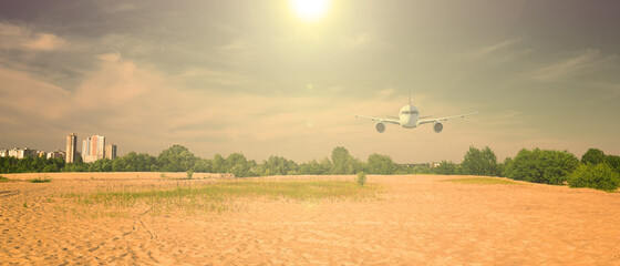 Airliner over the desert outside the city. The sun is shining