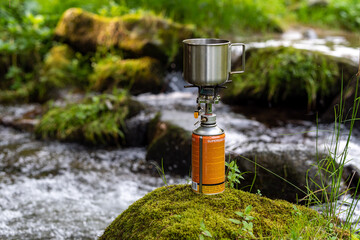 Photo metal mug  with coffee on burner.