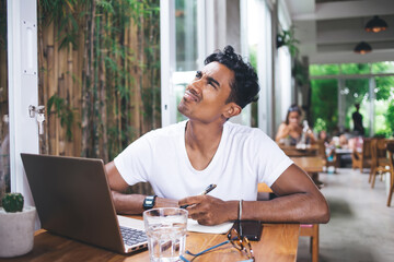 Ethnic young writer struggling to come up with ideas in cafe