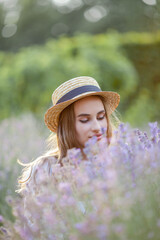 Beautiful young woman in the sunset light. Portrait of a beautiful woman in blooming lavender. Summer.