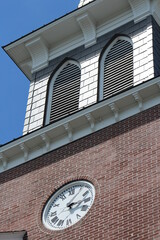 Fototapeta na wymiar roman numeral clock on side of a brick church steeple