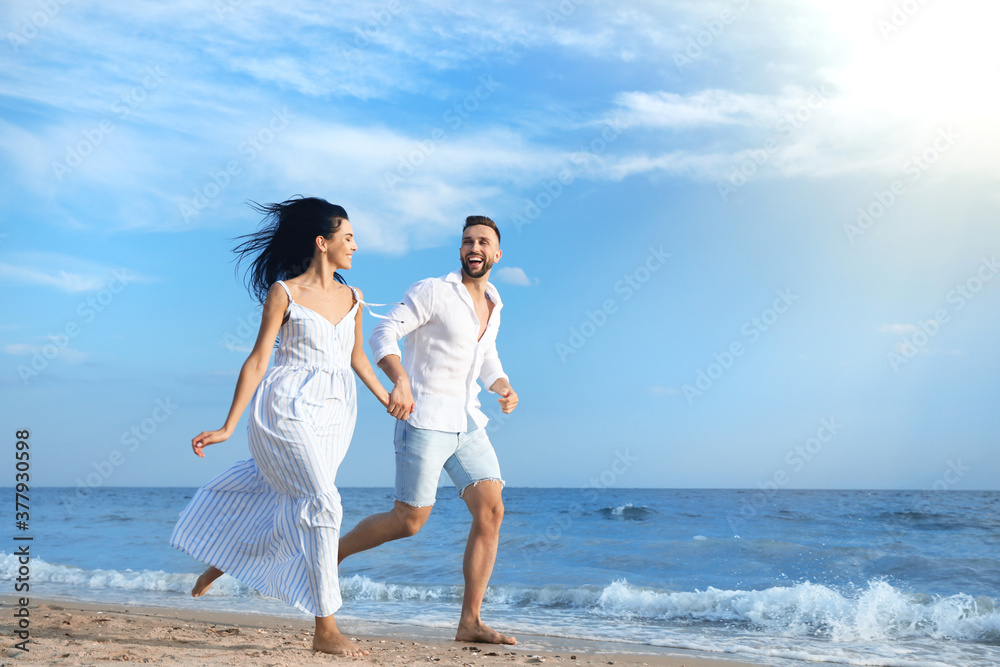 Canvas Prints Happy young couple running together on beach